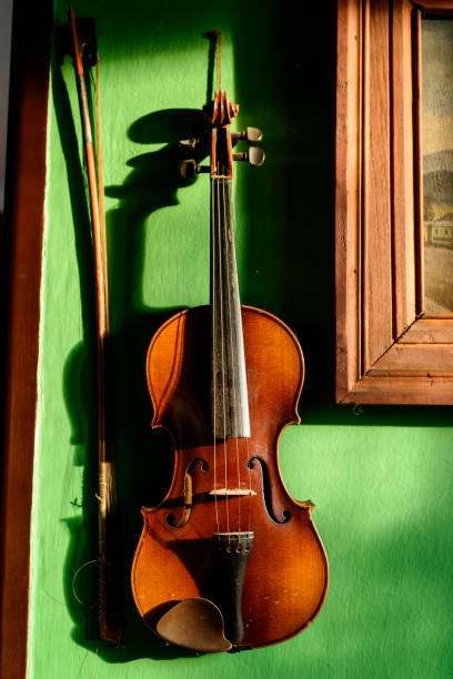 Violin with fiddle stick on the wall stock photo