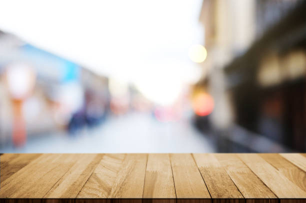 istock empty wooden deck, table top over blur outdoor market background. 1140795200