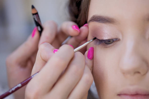 The work of a professional makeup artist. Stylist makeup artist doing makeup and hair in a beauty salon. The work of a professional makeup artist. Stylist makeup artist doing makeup and hair in a beauty salon. Professional make-up kruis stock pictures, royalty-free photos & images
