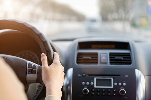 Close-up of hand holding a steering wheel driving