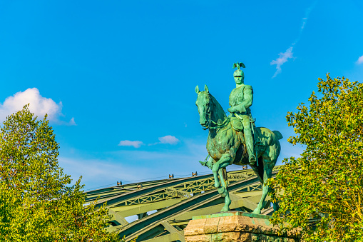 Hohenzollern bridge behind statue of emperor Wilhelm II in cologne, Germany