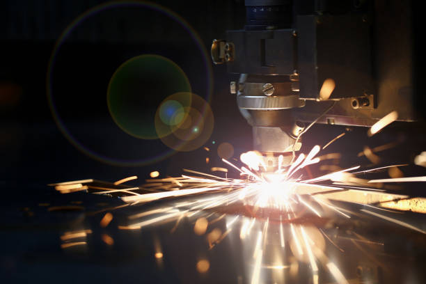 Sparks fly out machine head for metal processing Sparks fly out machine head for metal processing laser metal on metallurgical plant background. Manufacturing finished parts for automotive production concept equipment accuracy laser flame stock pictures, royalty-free photos & images