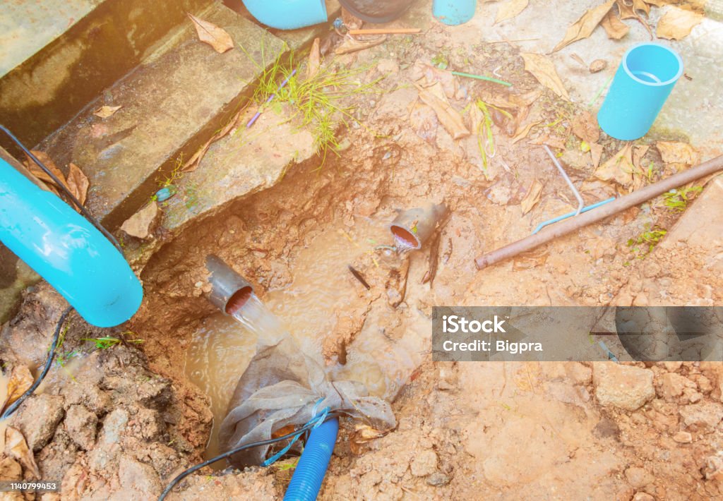 broken pipe in hole with water motion at roadside wait repair Trench Stock Photo