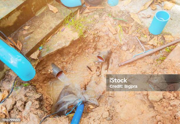 Broken Pipe In Hole With Water Motion At Roadside Wait Repair Stock Photo - Download Image Now