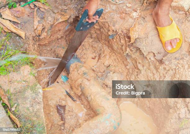 Broken Pipe In Hole And Water Motion At Roadside Plumber Working Repair And Saw On The Floor Soil With Cut Saw Stock Photo - Download Image Now