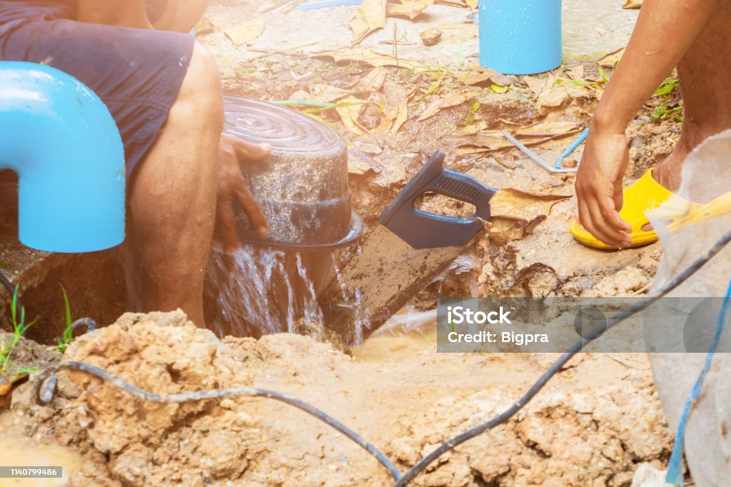 broken pipe in hole and water motion at roadside  plumber working repair and saw On the floor soil with cut saw Adult Stock Photo