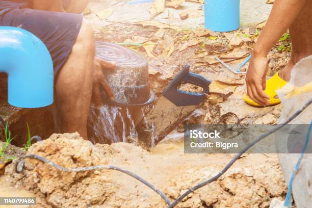 Broken Pipe In Hole And Water Motion At Roadside Plumber Working Repair And Saw On The Floor Soil With Cut Saw Stock Photo - Download Image Now