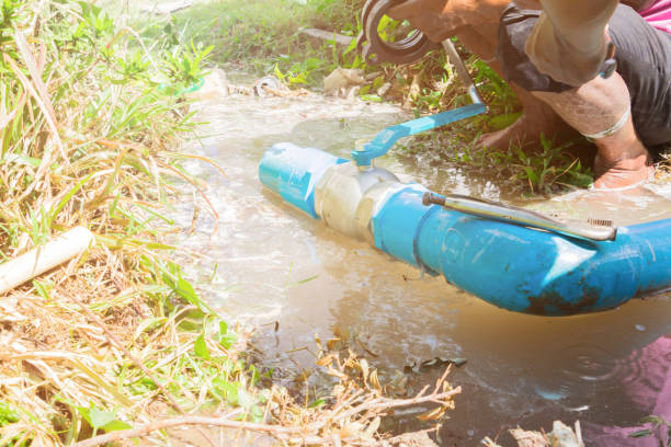 istock broken pipe in hole with water motion at roadside and plumber working repair and Locking Pliers 1140799568