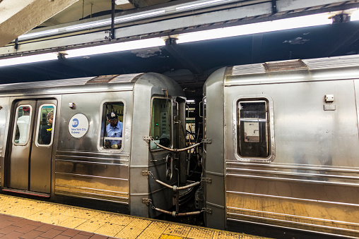 New York City, USA - July 30, 2018: Train car in motion with its driver looking and people around in a subway station of New York City, USA