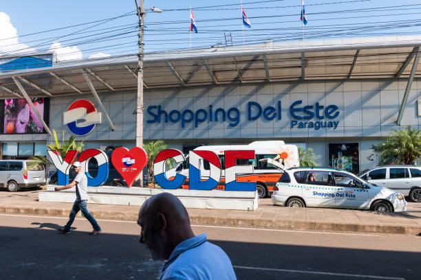 People walk past a shopping center in Ciudad del Este, a city in Paraguay connected by bridge to the Brazilian city of Foz do Iguaçu. It's a popular destination for Brazilians seeking to purchase products at a lower price than in Brazil. (March 28, 2019)