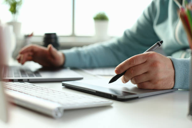 istock A young designer holds a pen from a tablet in his 1140800928