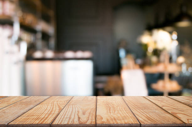 istock empty wooden desk over blurred coffee shop background 1140800992