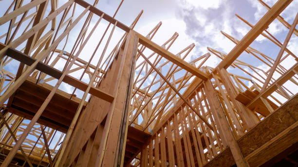 istock Looking up new construction beams under a clear blue sky with sunlight 1140801101