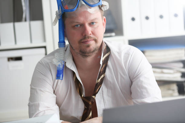 istock Man wearing suit and tie in goggles with snorkel 1140801774
