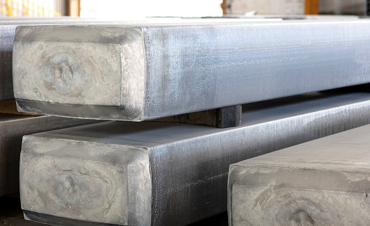 heavy aluminum slabs stacked in a warehouse foundry, raw material to be processed in a hot mill
