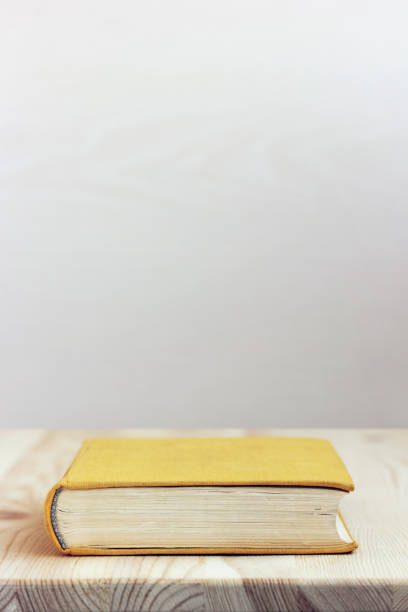 istock paper book with yellow cover on the table. space for text. 1140812973