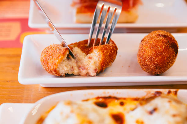 istock Male hands cutting Papas Rellenas (the most popular type of croquettes in Latin American countries) with knife and fork. 1140817035