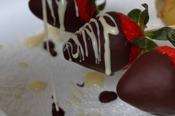 istock Strawberries glazed in black and white chocolate dries on a plate. On the work surface visible drops of chocolate. Cooking strawberries glazed in chocolate. 1140817774