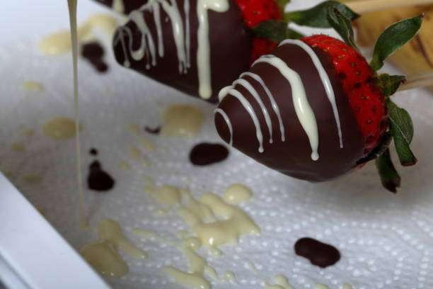 istock Strawberries glazed in black and white chocolate dries on a plate. On the work surface visible drops of chocolate. Cooking strawberries glazed in chocolate. 1140817776
