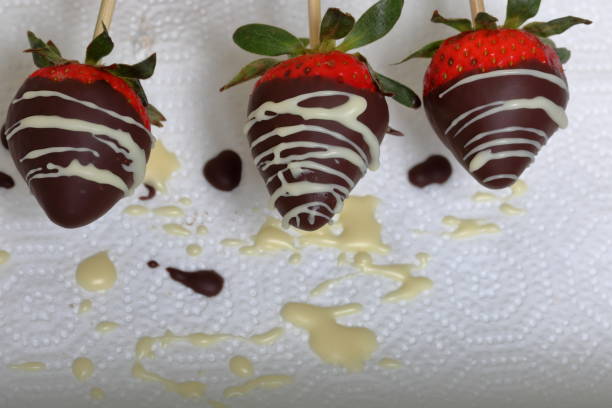 istock Strawberries glazed in black and white chocolate dries on a plate. On the work surface visible drops of chocolate. Cooking strawberries glazed in chocolate. 1140817781