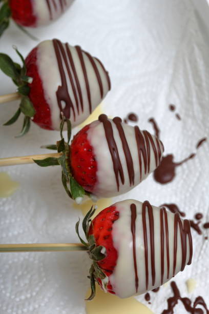istock Strawberries glazed in black and white chocolate dries on a plate. On the work surface visible drops of chocolate. Cooking strawberries glazed in chocolate. 1140817783