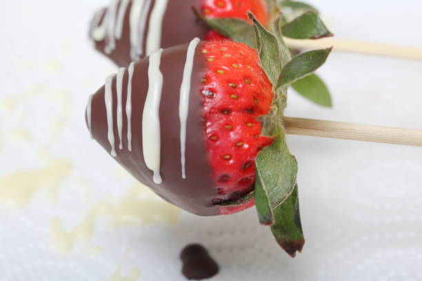 istock Strawberries glazed in black and white chocolate dries on a plate. On the work surface visible drops of chocolate. Cooking strawberries glazed in chocolate. 1140817785