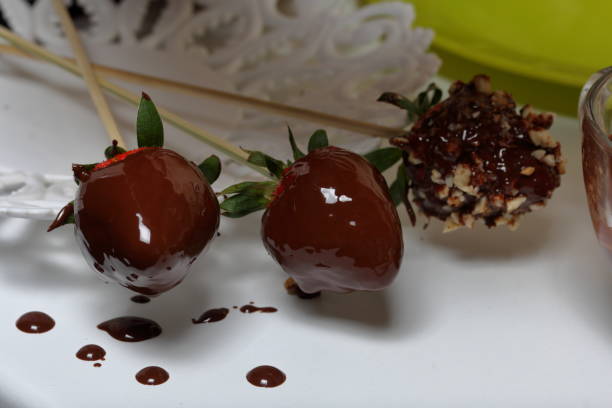 istock Strawberry glazed with dark chocolate dries on a plate. Cooking strawberries glazed in chocolate. 1140817792