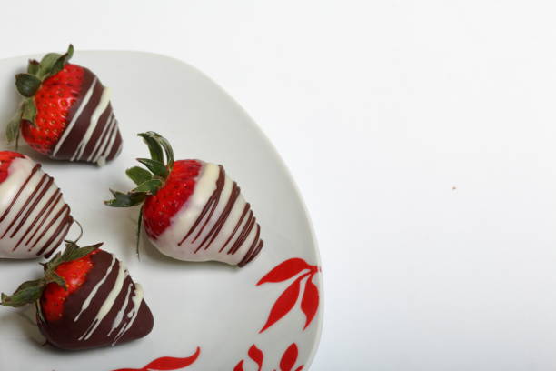istock Strawberries glazed in black and white chocolate. Lie on a white plate with a pattern. 1140817800
