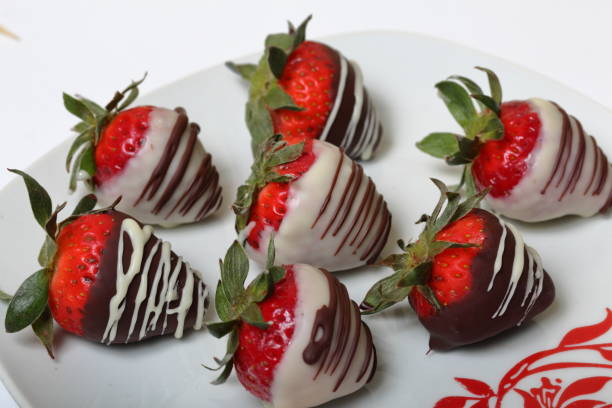istock Strawberries glazed in black and white chocolate. Lie on a white plate with a pattern. 1140817801
