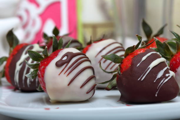 istock Strawberries glazed in black and white chocolate. Lie on a white plate with a pattern. 1140817806