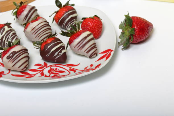 istock Strawberries glazed in black and white chocolate. Lie on a white plate with a pattern. 1140817810