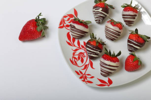 istock Strawberries glazed in black and white chocolate. Lie on a white plate with a pattern. 1140817811