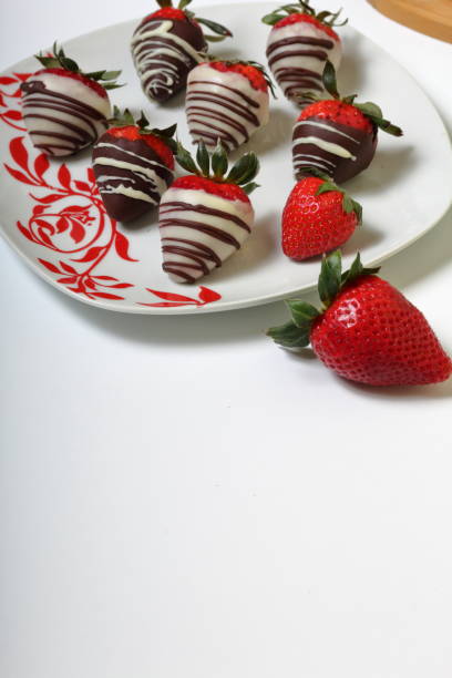 istock Strawberries glazed in black and white chocolate. Lie on a white plate with a pattern. 1140817816