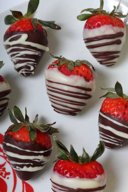 istock Strawberries glazed in black and white chocolate. Lie on a white plate with a pattern. 1140817818