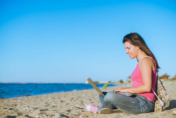 istock Woman using laptop on the beach 1140817897