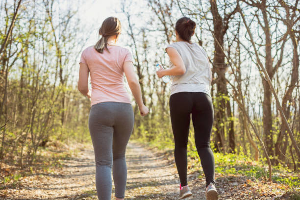 istock Two young women running in a forest 1140819247