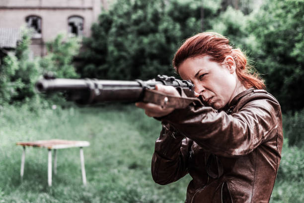 Young woman holding an old rifle
