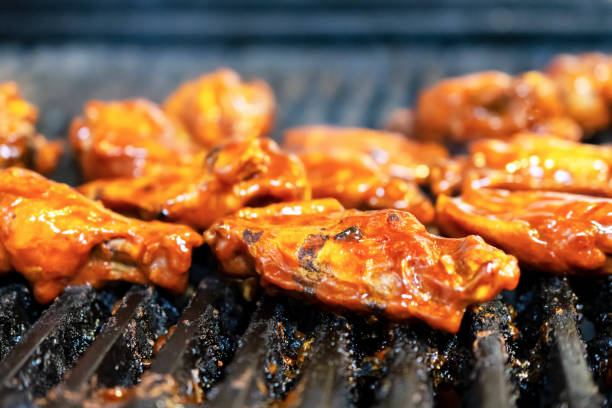 istock Chicken wings on restaurant grill starting to char, close up head on angle 1140820305