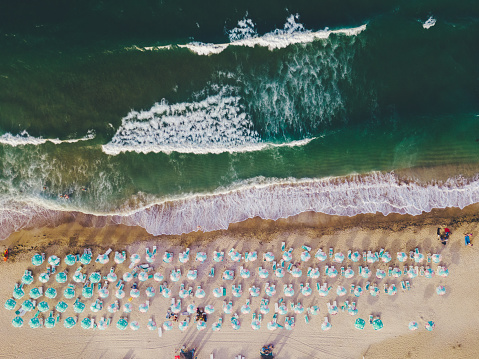 Drone point of view of small beach with sunshades