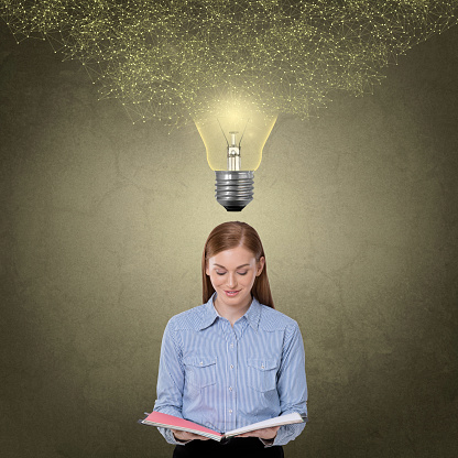 Woman holding diary under light bulb