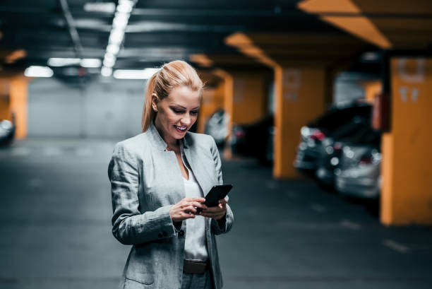 istock Successful woman using phone in underground parking. 1140823870