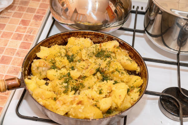 patate fritte con aneto in padella su stufa a gas - cast iron skillet foto e immagini stock