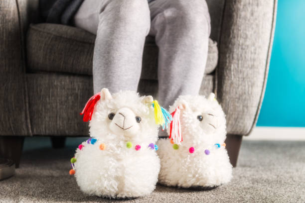 istock Young girl is wearing cute soft 3d llama slippers 1140828547