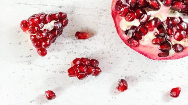 istock Tabletop view, pomegranate, gem like fruits scattered on white concrete board 1140832569