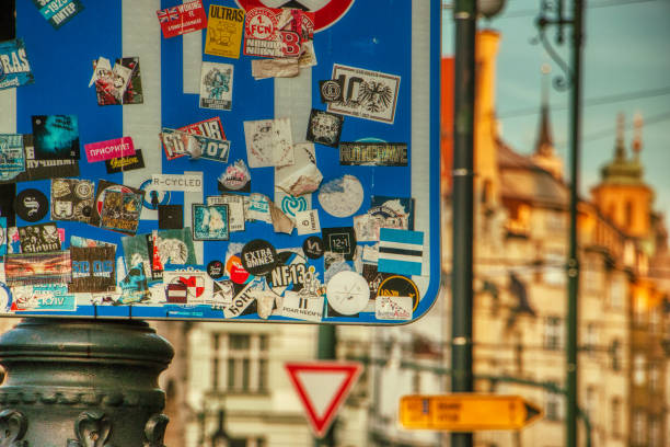 Prague, Czech Republic, March 31 2019 - street sign full of stickies of events, parties, street art over defocused background