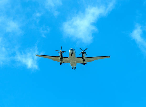 istock Twin propeller aircraft flying in a blue sky with clouds 1140835698