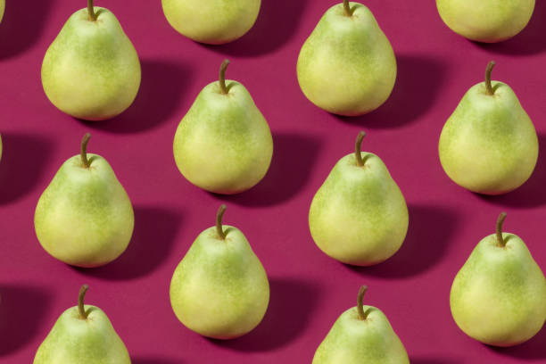 istock Green Pears on Purple Background 1140837304