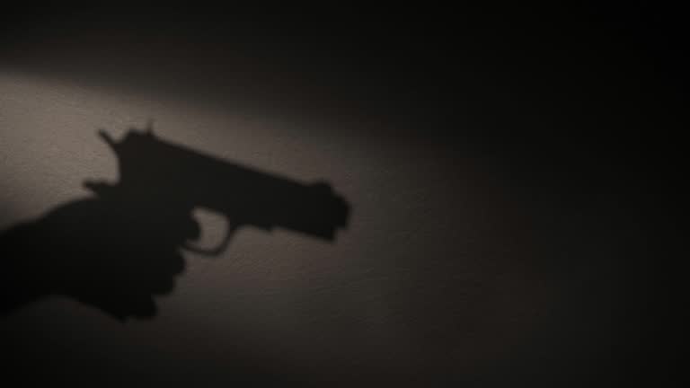 A shadow of a hand holding a gun in his hand.