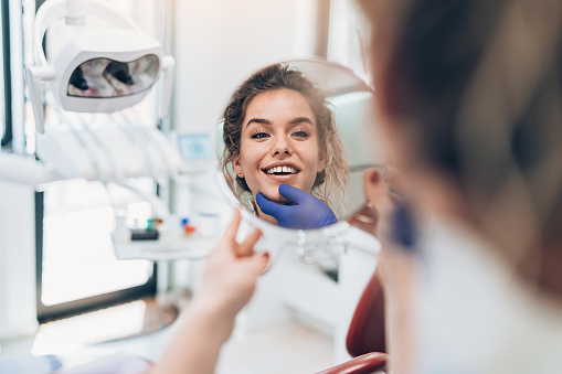 Female patient looking in a mirror in the dentist's office