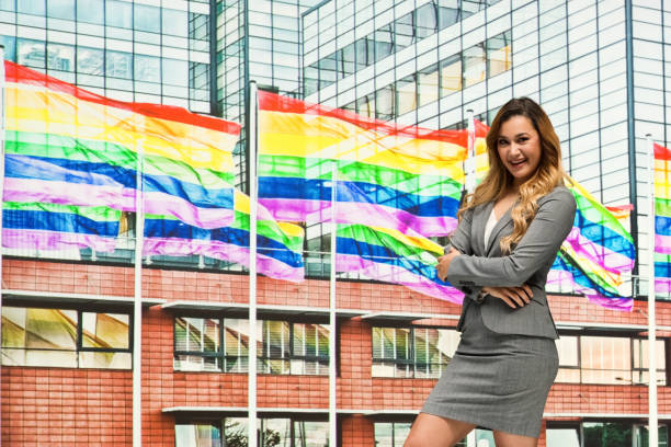 businesswoman in front of gay flag - homosexual gay pride business rainbow imagens e fotografias de stock